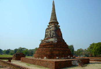 Fototapeta premium THAILAND AYUTTHAYA. Wat Phra Mahatat, built in the 14th century, area dotted with small chedis and Khmer towers notably has a head of a Buddha statue where tree roots have grown around