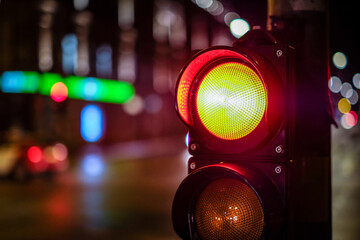 Red light on pedestrian traffic light in the street junction in the city with beautiful bokeh lights in the night. Defocused