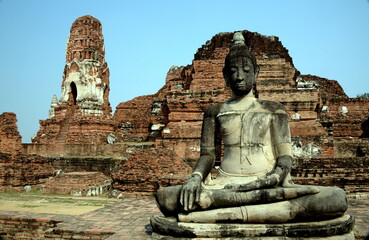Fototapeta premium THAILAND AYUTTHAYA. Wat Phra Mahatat, built in the 14th century, area dotted with small chedis and Khmer towers notably has a head of a Buddha statue where tree roots have grown around