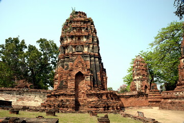 THAILAND AYUTTHAYA.  Wat Phra Mahatat, built in the 14th century, area dotted with small chedis and Khmer towers notably has a head of a Buddha statue where tree roots have grown around