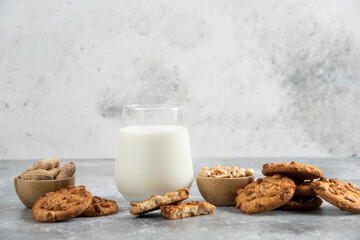 Cookies with organic peanuts and honey with glass of milk on marble background