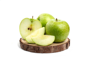 Whole and sliced green apples on wood piece on white background