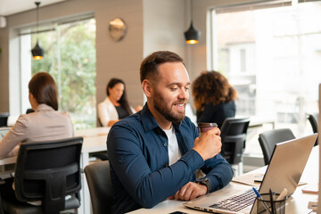 brazilian business man relaxing and taking a break with a cup of coffee in the office. .