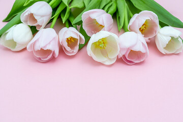 Fototapeta na wymiar Bouquet of pink tulips on pink background. Mothers day, Valentines Day, Birthday celebration concept. Greeting card. Copy space for text, top view.