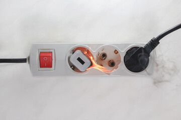 Inflamed plug in power board - result of electrical short circuit, selective focus