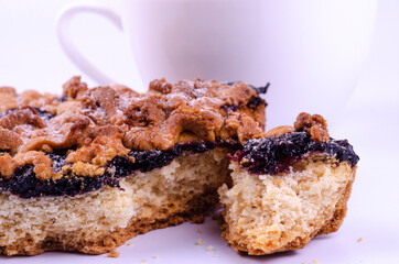 Appetizing homemade pie with fruit jam on a background of a cup of tea, morning lunch