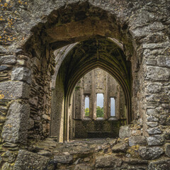 Fototapeta na wymiar View through window to Hore Abbey abandoned interior with decorative arches. Located next to Rock of Cashel castle, County Tipperary, Ireland