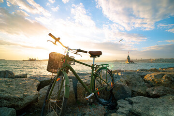 Fototapeta na wymiar Bicycle on the rocks and cityscape of Istanbul on the background at sunset