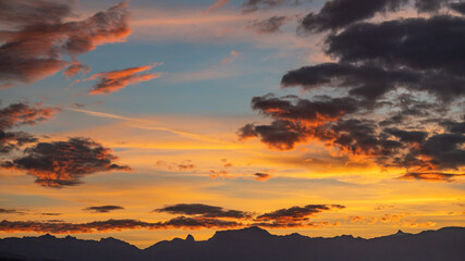 Sunset over the mountains. Dramatic sky at sunset with red, yellow and orange colors. Lausanne, Switzerland.