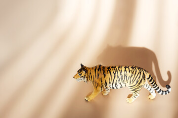 Tiger symbol of the Chinese new year 2022. Figurine of tiger isolated on pastel background with shadows. Copy space.