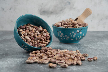 Raw bean grains displayed in bowls on marble surface