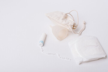 Photo of tampon, menstrual cup.Concept of critical days, menstruation, over white background