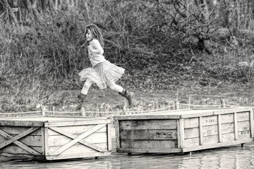 girl runs over crates in the water