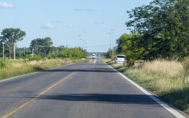 Fototapeta na wymiar Thin road, straight, car on the right bump