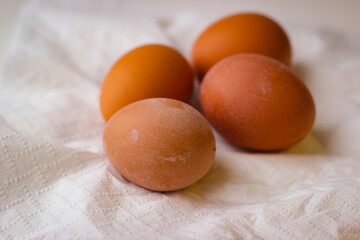 Four red chicken eggs on a white paper napkin