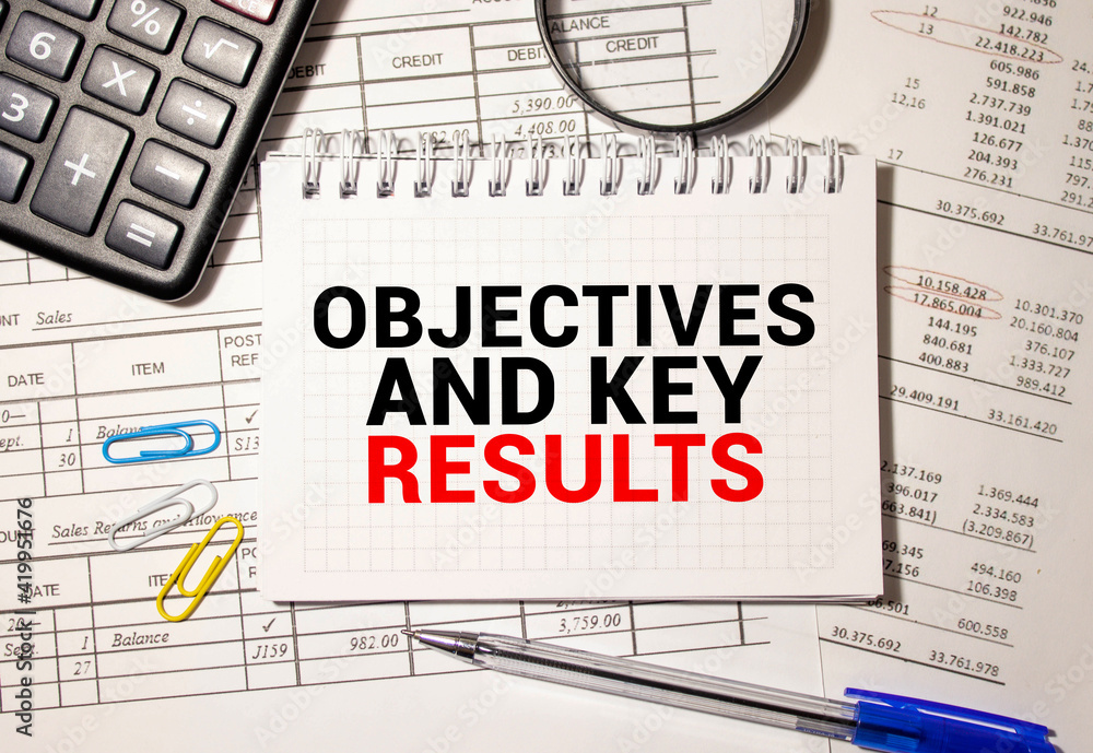 Poster objective key results okr text in the office notebook. view from above