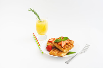 Breakfast with belgium waffles with mint on plate and orange juice