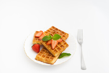Tasty sweet belgium waffles with strawberry decoration on plate
