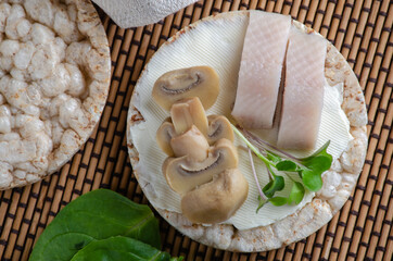 Diet popped wheat cakes with herring, champignons and greens.