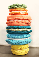 Huge colorful plastic macaroons decor in a stack for birthday or celebration for decorating photo zone. Ugly food. Dieting concept.  