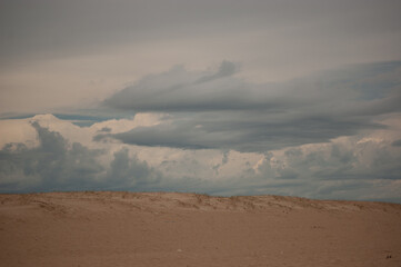 Fototapeta na wymiar Nubes oscuras tras la duna de la playa