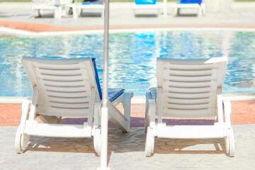 beautiful chaise lounges by the pool on nature at sea background