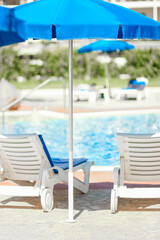 beautiful chaise lounges by the pool on nature at sea background