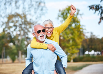 senior couple love together happy hug home family elderly man woman retirement smiling piggyback