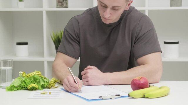 A man of athletic build makes a diet plan