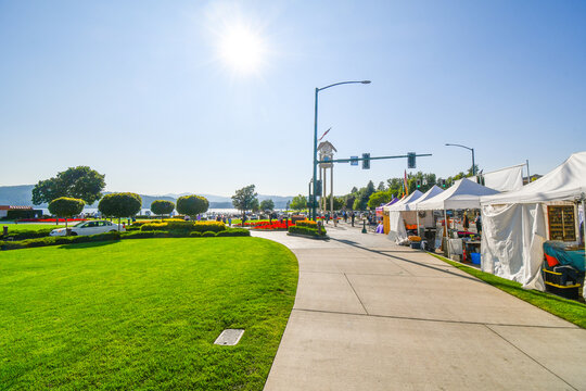 Sellers and artists set up booths along Sherman Ave. with the resort and lake in the distance during a local art festival.