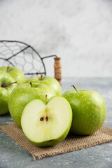 Metal bucket of fresh green apples on marble background