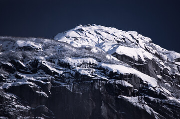 pico de la montaña con nieve bajo un cielo oscuro