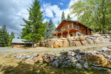 A rustic log cabin and detached shop or garage in the rural mountains of Coeur d'Alene, Idaho, USA