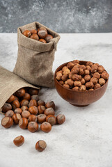 Pile of organic shelled and kernels of hazelnuts in burlap and in bowl