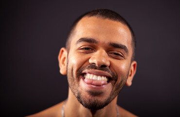 young blackskin guy smiling, showing tongue isolated on studio background