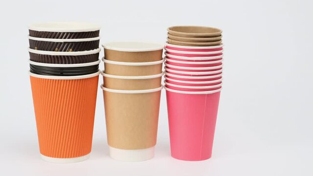 stack of disposable paper cups for coffee and tea on a white background, hand puts, zero waste 