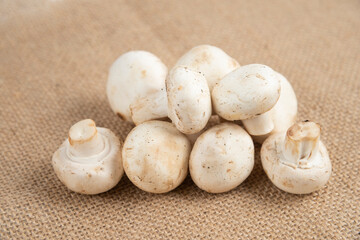 White mushrooms isolated on a piece of burlap