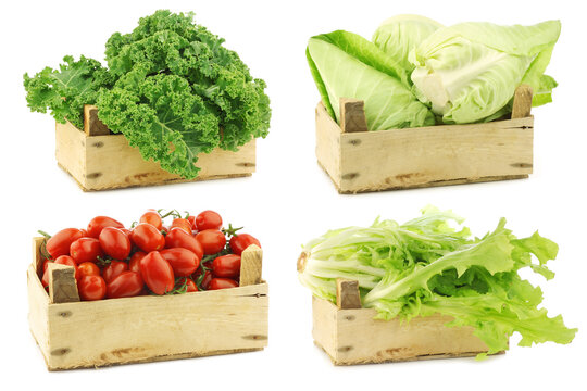 Fresh cooking vegetables in a wooden crate on a white background