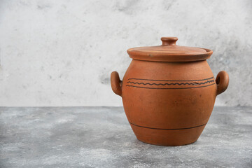 Single clay antique vase placed on marble surface