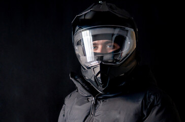Motorcyclist wearing a black dual-purpose motorcycle helmet with a black jacket.