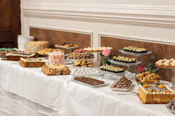 Beautifully decorated wedding table. Table setting. Tangerines, grapes, blueberries, kiwi and other fruits and berries, cookies and all sorts of goodies.