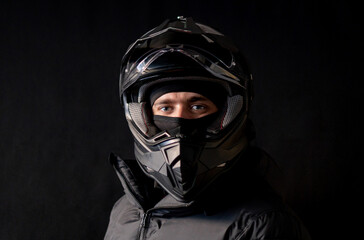 Motorcyclist wearing a black dual-purpose motorcycle helmet with a black jacket.