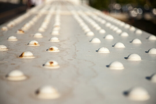 Selective Blur On White Metal Rivets On An Industrial Metallic Bridge, Some Old And Rusted. They Are A Symbol Of Heavy Industry, Steelwork And The First Industrial Revolution. 