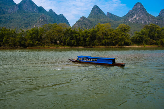 Nice tourists boat travel route view on mountains and hills covered by forest in Guilin, China
