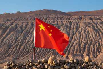 Five starred China national flag designed by Zeng Liansong waving in the wind with the flame mountain on background