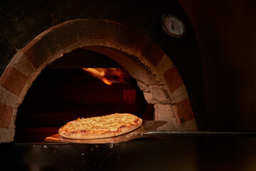 pizza saliendo del horno con llamas