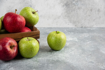 Bunch of fresh green and red apples placed in wooden box