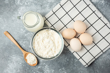 Bowl of flour, eggs and milk on marble surface