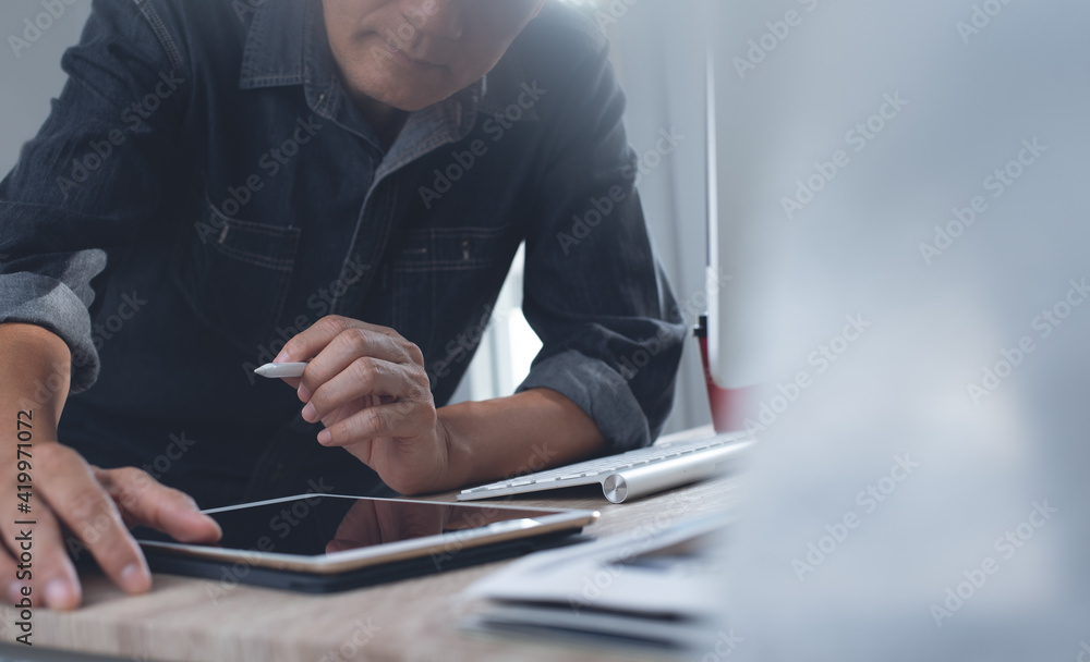 Poster man graphic designer working on desktop computer and digital tablet in modern office