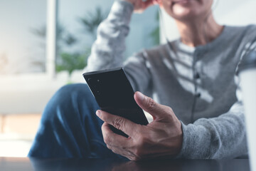 Casual man with earphone using mobile phone listening to music at home
